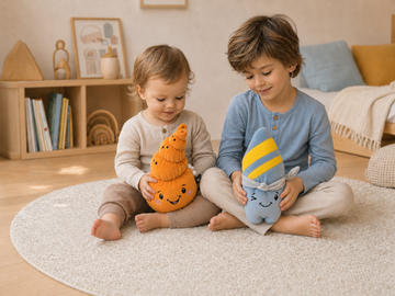 Zwei Kinder unterschiedlichen Alters hören mit den smarten Kuscheltieren Mia und Nalu altersgerechte Hörspiele in einem hellen Kinderzimmer.