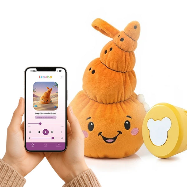 Der muschelförmige Lenabo Charakter Mia steht rechts im Bild. Die orangefarbene Stofffigur mit freundlichem Gesicht und rosa Wangen ist neben einem gelben Lenabo Smart Speaker platziert. Links hält eine Person ein Smartphone mit der geöffneten Lenabo App, die die Geschichte ‚Das Flüstern im Sand‘ zeigt, inklusive Wiedergabesteuerung.